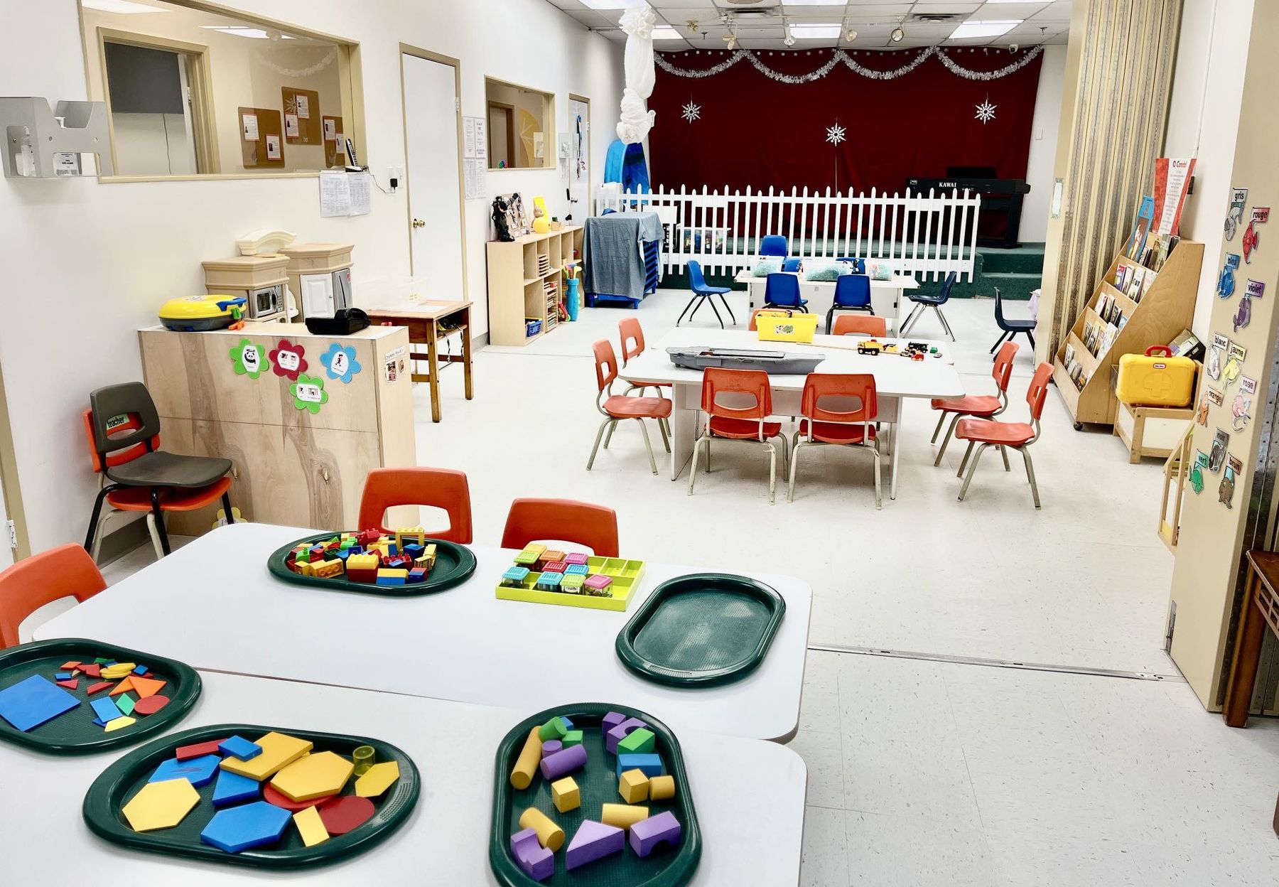 Kindergarten tables set with trays of colourful pattern blocks